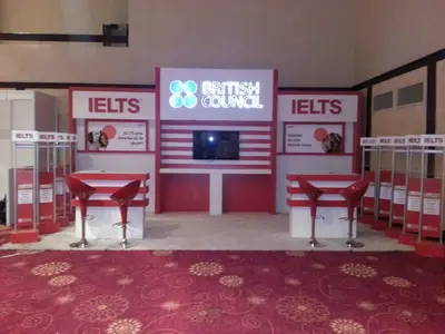 British Council IELTS — stand de feria — almacenaje bajo mostrador, blanco (la unidad ya instalada)