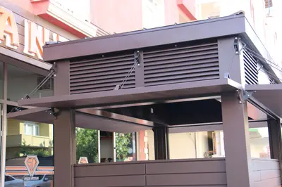 Emaar Square — Straßenkiosk — Holzfurnier, Bronze (im Straßenraum)