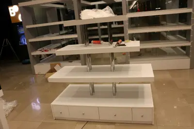 May Gift Shop — mall kiosk — white laminate panels, under-shelf LED strip (on-site assembly)