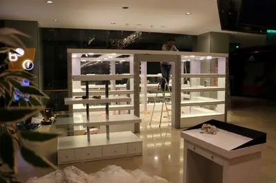 May Gift Shop — mall kiosk — full-length glass display cases, backlit sign (on-site assembly)