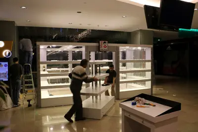 May Gift Shop — mall kiosk — full-length glass display cases, anthracite (on-site assembly)