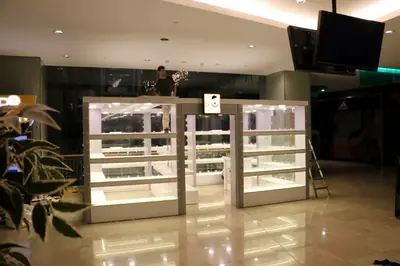 May Gift Shop — mall kiosk — crown signage above the unit, anthracite (on-site assembly)