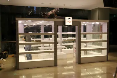 May Gift Shop — mall kiosk — tempered glass display cases, anthracite (on-site assembly)