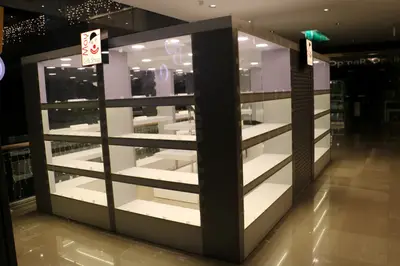 May Gift Shop — mall kiosk — full-length glass display cases, under-shelf LED strip (the unit installed in place)