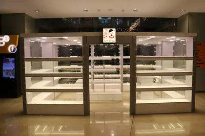 May Gift Shop — mall kiosk — tempered glass display cases, under-shelf LED strip (the unit installed in place)