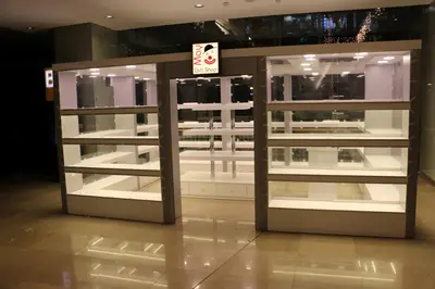 May Gift Shop — mall kiosk — cross-plan island footprint, backlit sign (the unit installed in place)