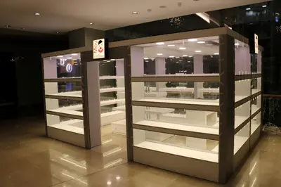 May Gift Shop — mall kiosk — full-length glass display cases, backlit sign (the unit installed in place)
