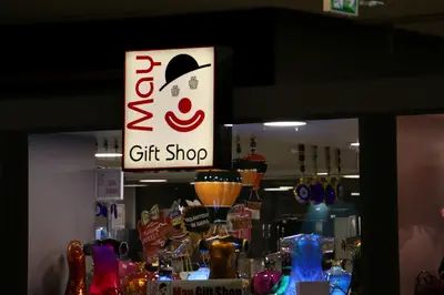 May Gift Shop — mall kiosk — crown signage above the unit, red (the unit installed in place)