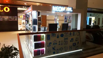 Neomobil — AVM kiosku — boydan boya cam vitrin, arkadan aydınlatmalı tabela