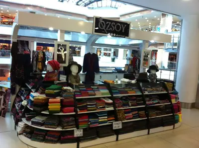Özsoy Eşarp — Olivium — mall kiosk — tiered open shelving, white