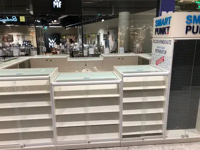 Smartpunkt — mall kiosk — multi-faceted polygonal footprint, under-shelf LED strip