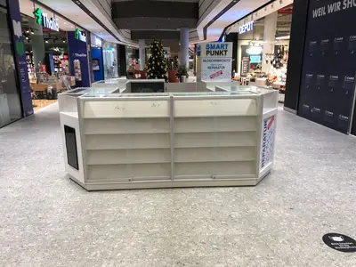 Smartpunkt — mall kiosk — crown signage above the unit, under-shelf LED strip