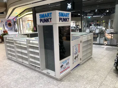 Smartpunkt — mall kiosk — black gloss surfacing, under-shelf LED strip