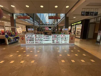Smartpunkt — mall kiosk — crown signage above the unit, white