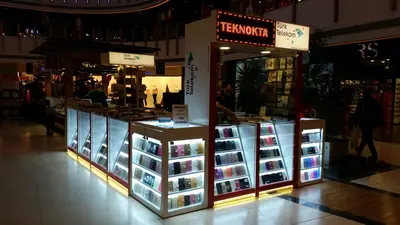 Teknokta Pendorya — AVM kiosku — beyaz laminat panel, raf altı LED şerit (yerine kurulmuş hâli)