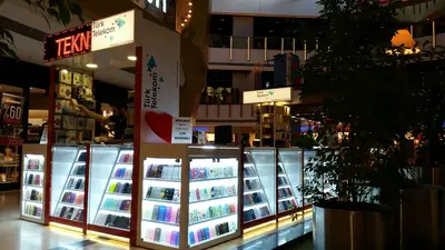 Teknokta Pendorya — AVM kiosku — ahşap tonlu laminat, raf altı LED şerit (yerine kurulmuş hâli)