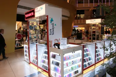 Teknokta Pendorya — AVM kiosku — kademeli açık raf, ahşap tonu (yerine kurulmuş hâli)