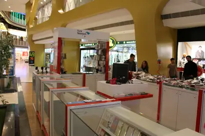Teknokta Pendorya — AVM kiosku — kademeli açık raf, arkadan aydınlatmalı tabela (ürün dizilmiş çalışır hâli)