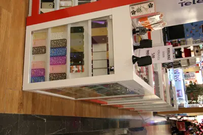 Teknokta Pendorya — AVM kiosku — ahşap tonlu laminat, arkadan aydınlatmalı tabela (ürün dizilmiş çalışır hâli)