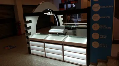 Turkcell Platinium — AVM kiosku — düz kanopi ve alın bandı, arkadan aydınlatmalı görsel panel (sahada montaj)