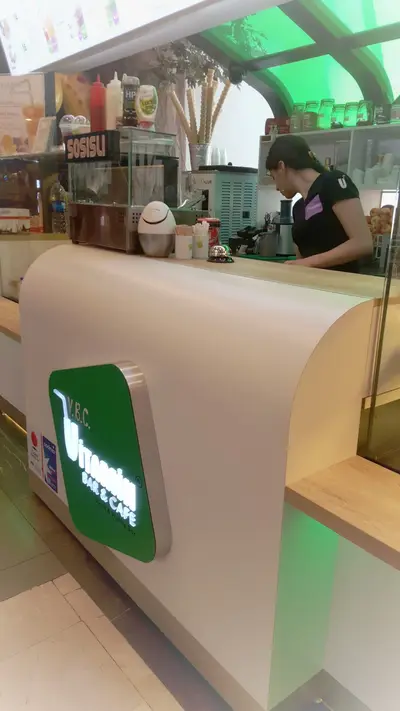 V&C Vitamin Bar & Cafe — AVM kiosku — temperli cam vitrin, yeşil LED şerit