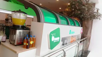 V&C Vitamin Bar & Cafe — AVM kiosku — arka hazırlık alanı, arkadan aydınlatmalı tabela